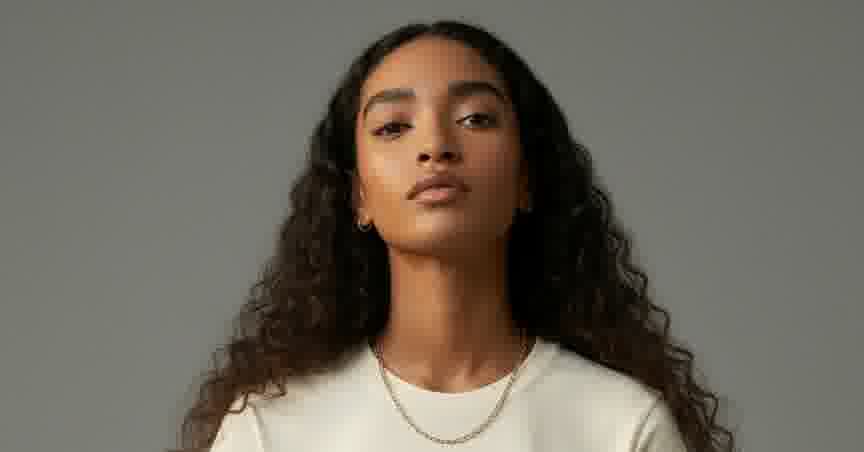 MODA AI catalog photography — model in cream graphic t-shirt with deliberate face and background reference composition